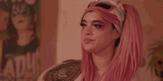 a woman with pink hair and a mask on her head