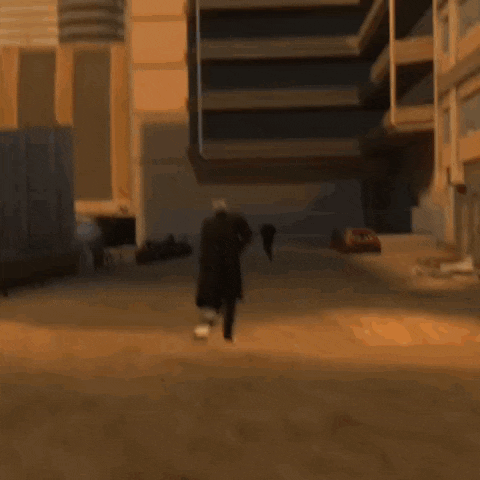 a man is walking down a street in front of a building on fire