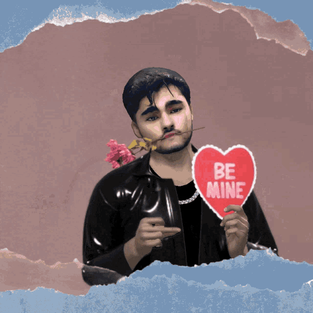 a man with a rose in his mouth is holding a be mine heart