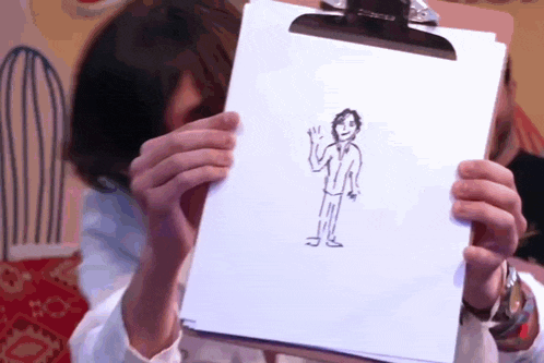 a person holds up a drawing of a man on a clipboard