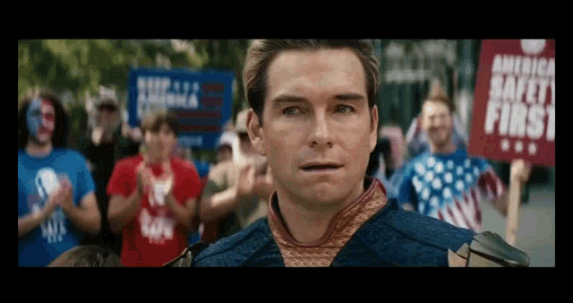 a man is standing in front of a crowd holding a sign that says america safety first