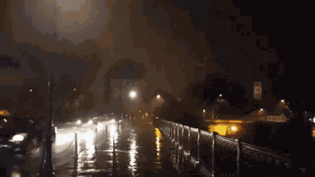 a flooded street at night with a car driving down it