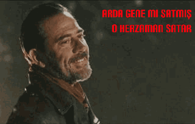 a man with a beard is smiling with the words " arda gene mi satomis o herzaman satar " behind him