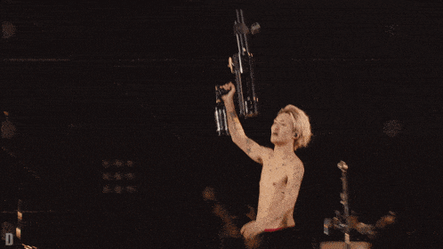a man in a metallica shirt is holding up a gun