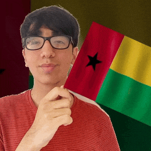 a man wearing glasses is holding a red yellow and green flag with a black star