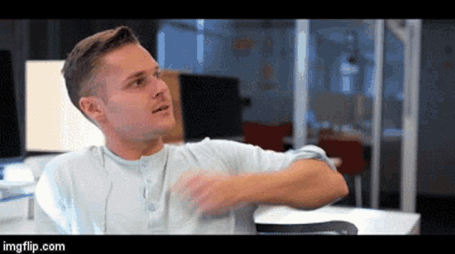a man is sitting at a desk with his arm outstretched and the url imgflip.com is displayed