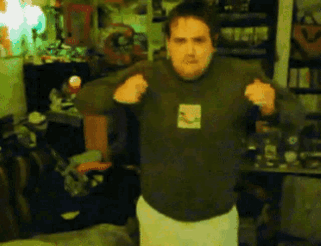 a man wearing a green sweater with a picture of a cat on the front