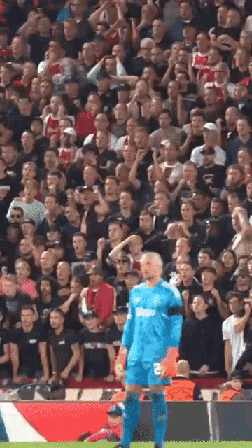 a soccer player stands in front of a crowd wearing a blue jersey that says bwin on it