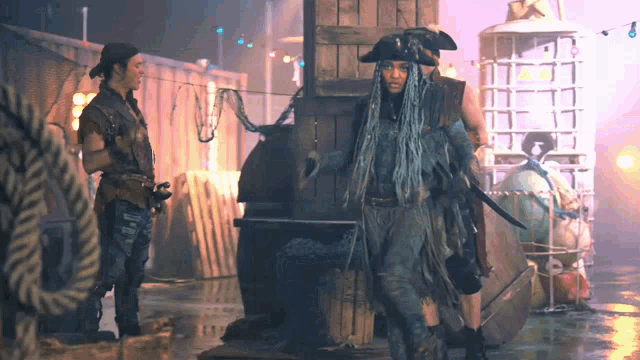 a man in a pirate hat stands next to a woman in a pirate outfit