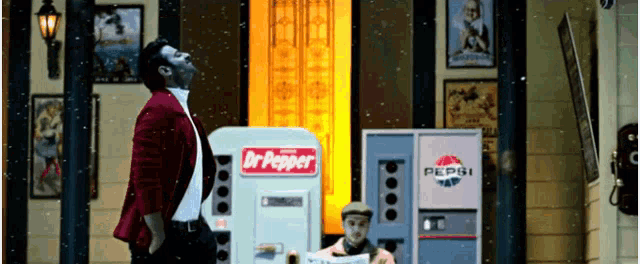 a man stands in front of a dr pepper machine