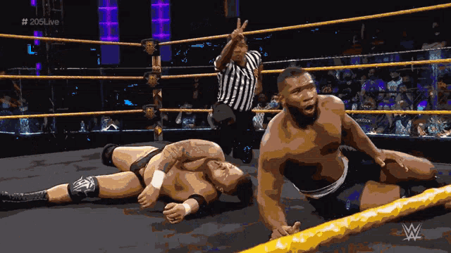 two wrestlers in a wrestling ring with # 205live on the bottom right