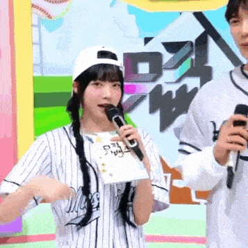 a girl in a striped shirt is holding a microphone
