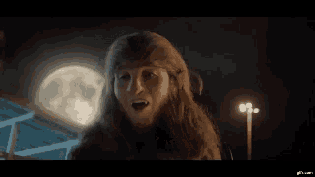 a woman in a fur hat is standing in front of a full moon
