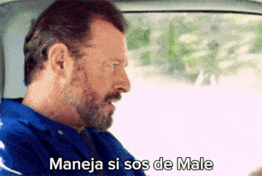 a man with a beard is driving a car and says " maneja si sos de male "