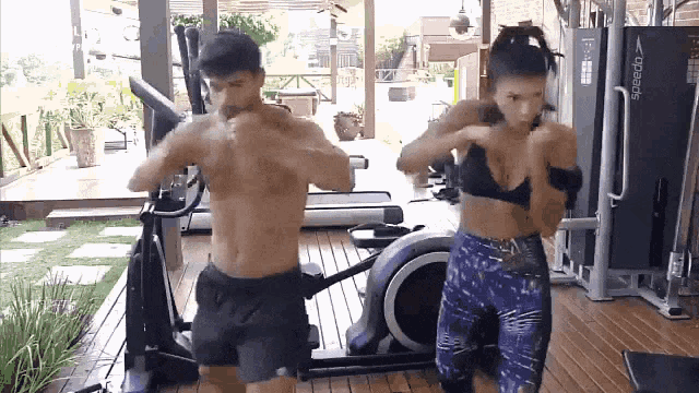 a man and a woman are doing exercises in a gym that says reebok on it