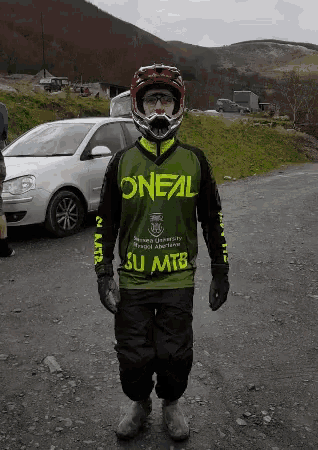 a man wearing a helmet and a green oneal shirt