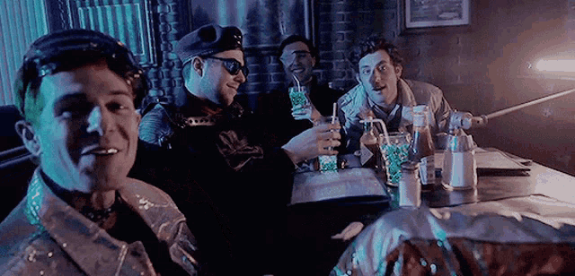 a group of men are sitting at a table with drinks