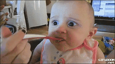 a baby is being fed with a spoon and has a surprised look on his face .
