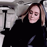a woman is sitting in the back seat of a car wearing a scarf .