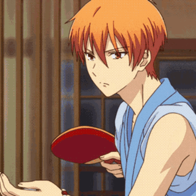 a boy with orange hair is holding a ping pong paddle in his hand
