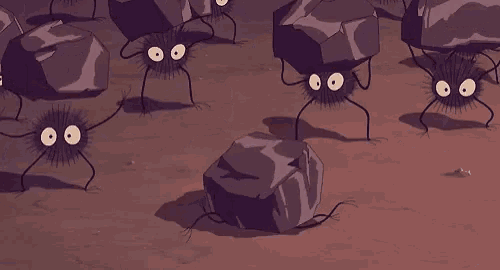 a group of cartoon spiders are crawling on a pile of rocks on the ground .