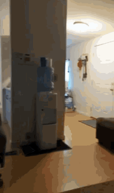 a water cooler sits in a living room next to a door