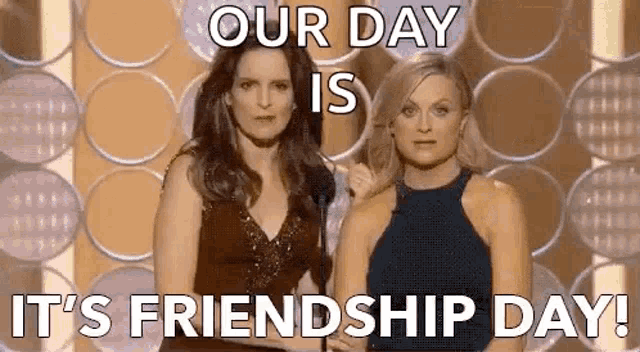 two women are standing next to each other on a stage with a microphone .