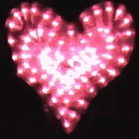 a heart made of pink lights on a black surface