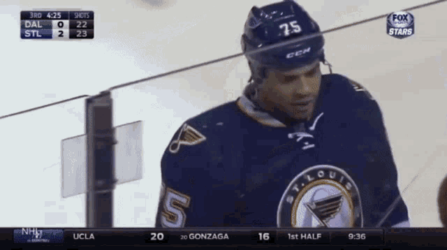 a hockey player with the number 75 on his helmet stands on the ice