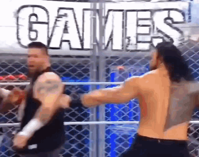two men are fighting in a wrestling ring with a sign in the background that says games .