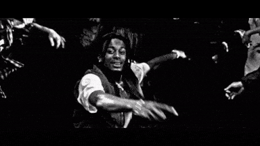 a black and white photo of a man with dreadlocks