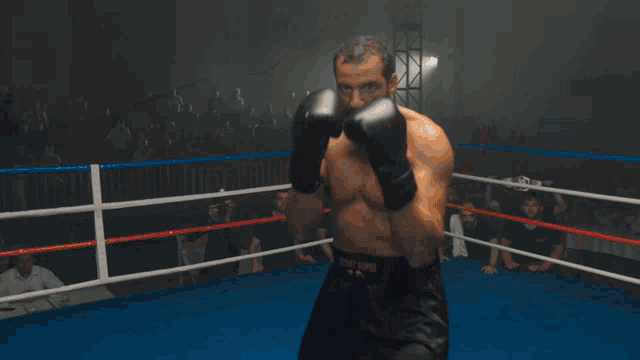a close up of a person wearing boxing gloves in a boxing ring