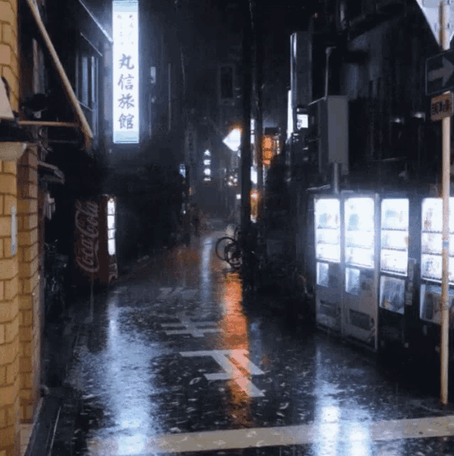 a coca cola vending machine is in the middle of a wet street