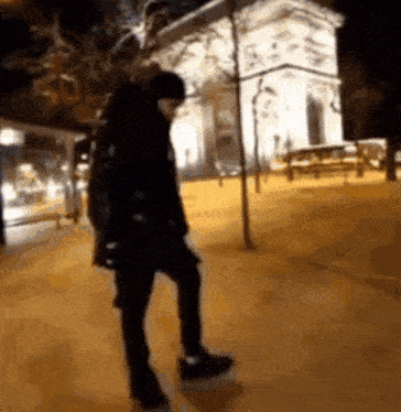 a blurry picture of a person walking on a sidewalk at night