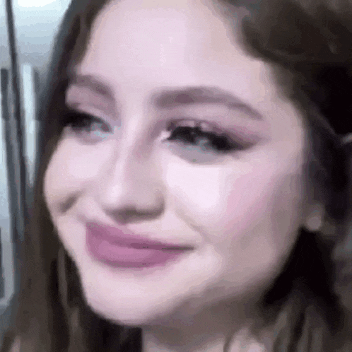 a close up of a woman 's face with a pink lip gloss on .