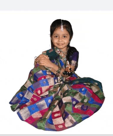 a little girl is wearing a colorful dress and sitting on a white background .
