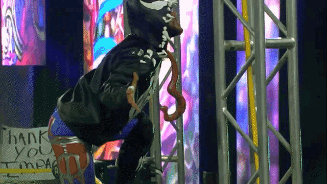 a person in a venom costume is standing in front of a sign that says thank you