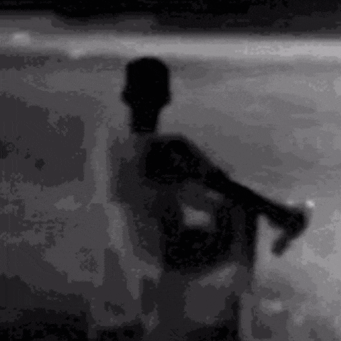 a silhouette of a man standing on a beach holding a can of soda .