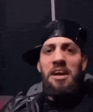 a man with a beard is making a funny face with his tongue out .