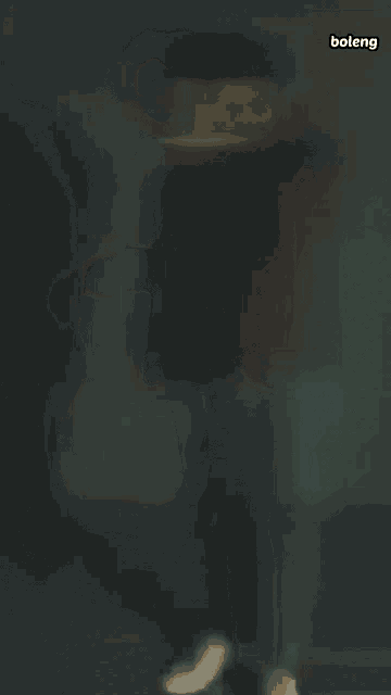 a blurry picture of a man standing in front of a light with the word boleng on the bottom