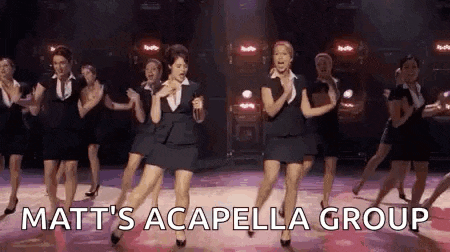a group of women are dancing on a stage with the words `` matt 's acapella group '' written on the bottom .