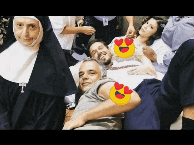 a group of people posing for a picture including a nun and a man with hearts on his eyes