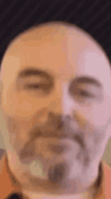a close up of a man 's face with his eyes closed and a beard .