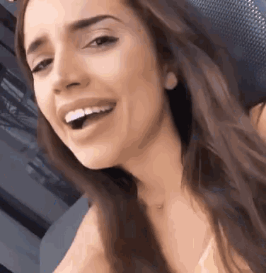 a close up of a woman 's face smiling with her mouth open