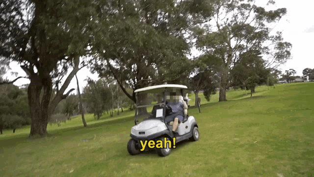 a golf cart is driving down a grassy hill and says yeah