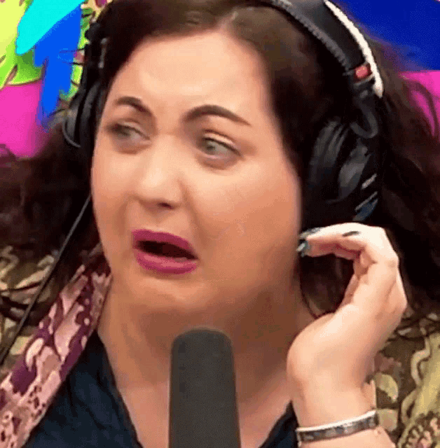 a woman wearing headphones is making a funny face