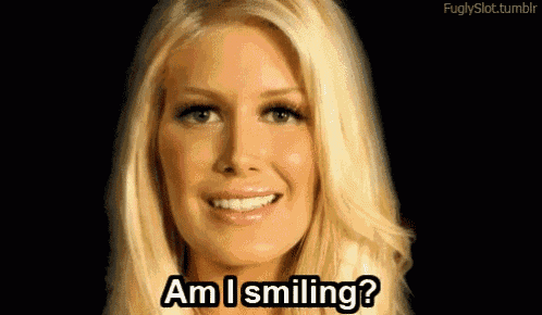 a blonde woman is smiling and asking am i smiling