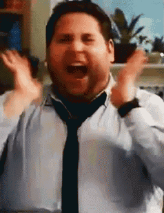 a man wearing a tie and a white shirt is making a funny face