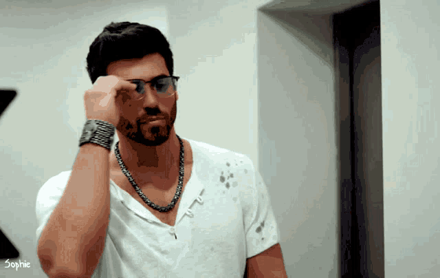 a man wearing glasses and a white shirt with the word sophie on the bottom right