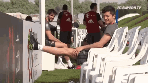a man stretching his legs while sitting in a row of chairs
